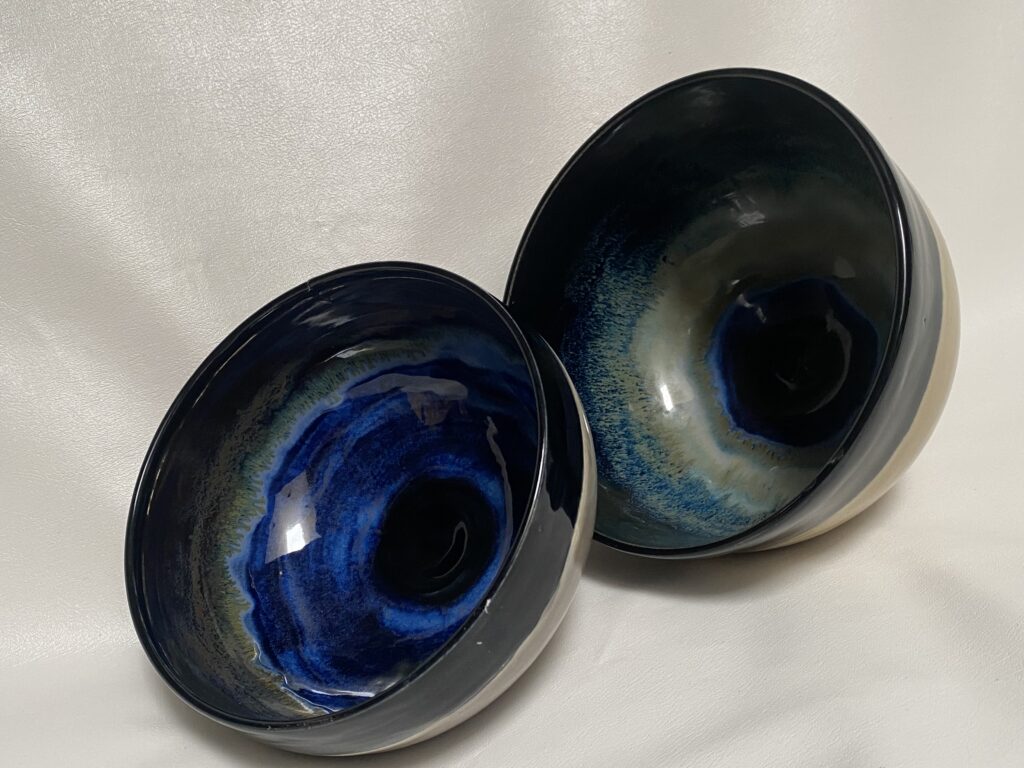 Two hand made bowls with blue interiors