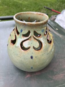 A sage green carved vase by Lesley