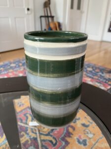 A dark green, light blue, and white stripped vessel by Rose.