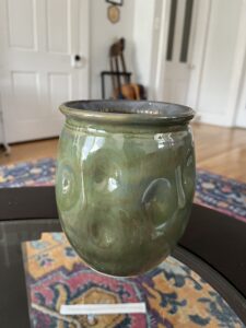 A majestic olive green vase that's been altered with a dimpled pattern